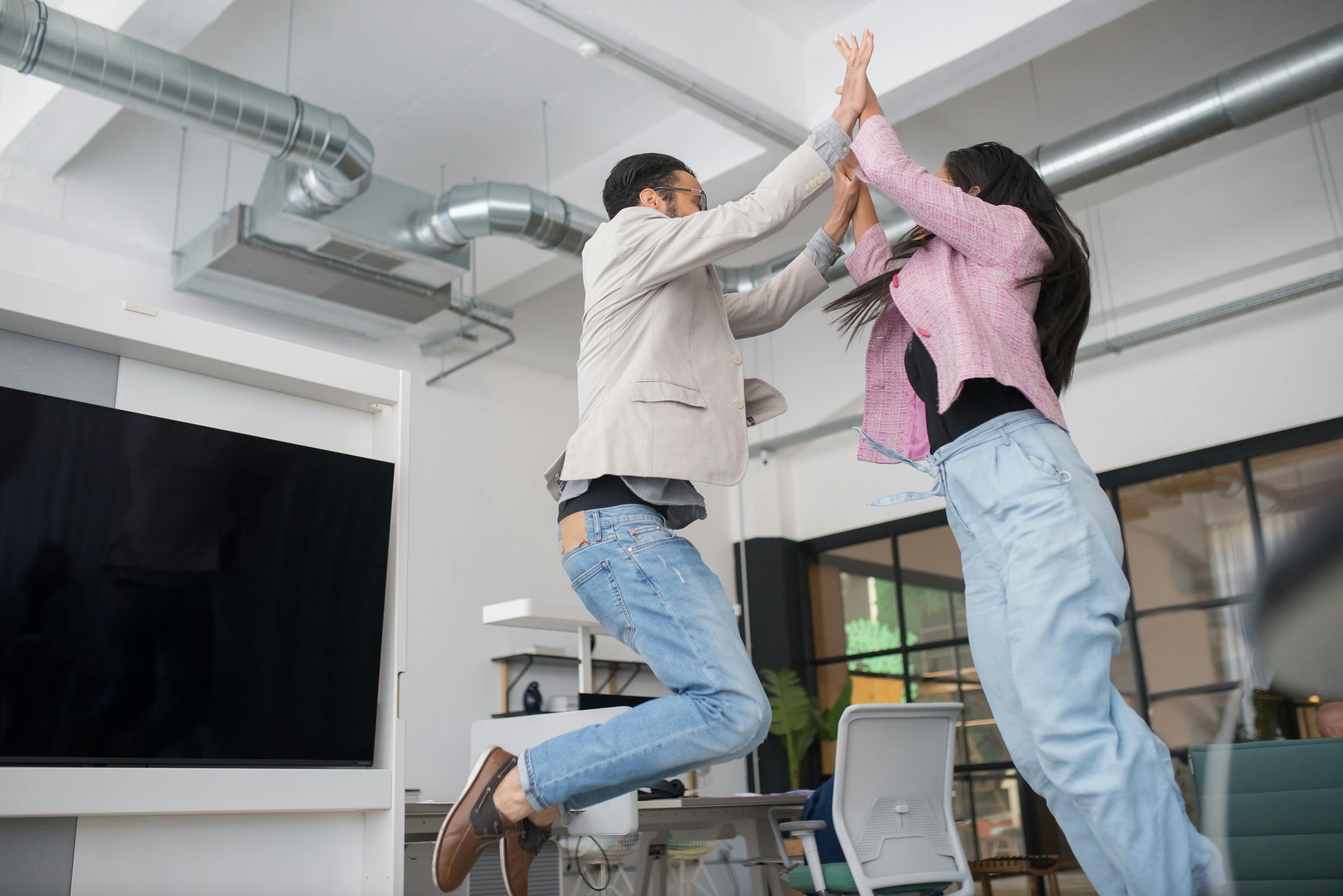 Business professionals celebrating real estate exam prep success in a modern office